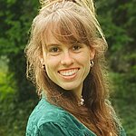 Saskia Effert vor einer grünen Hecke