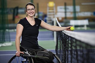 Britta Wend im Rollstuhl am Tennisnetz